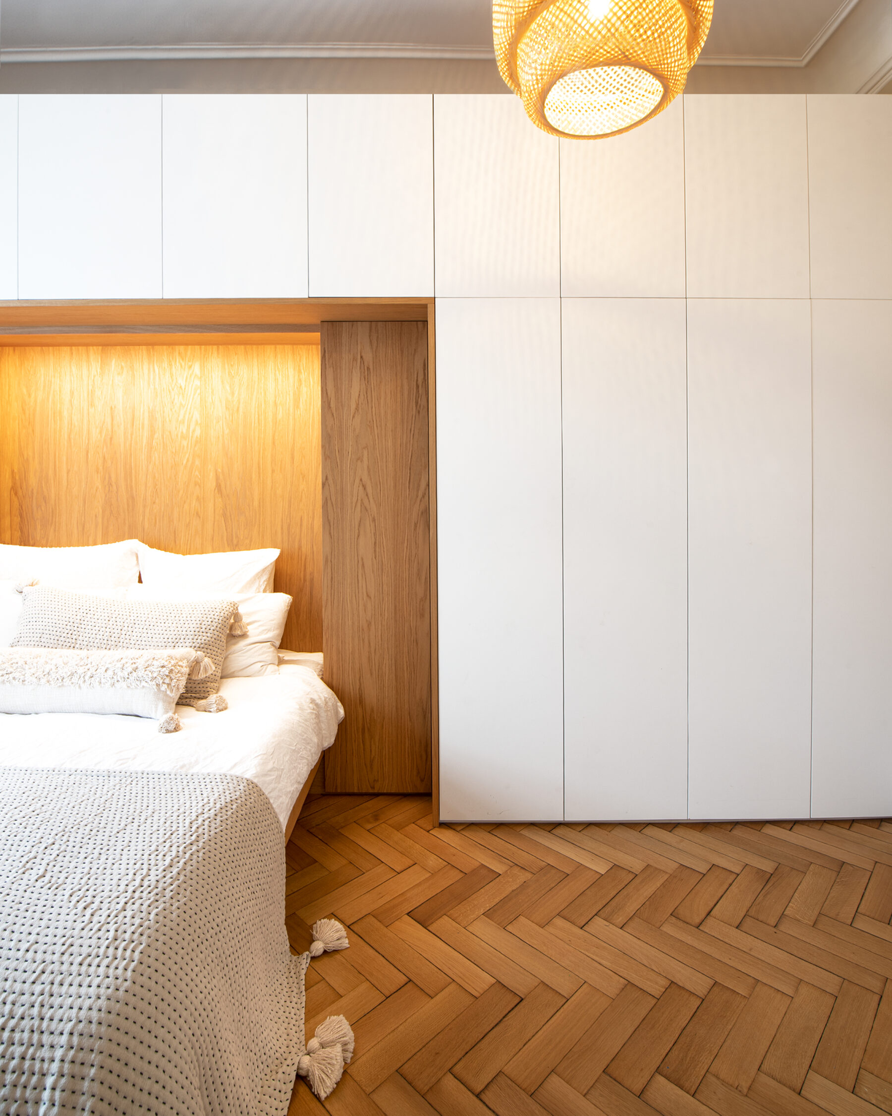 Moderne Schrankwand mit integriertem Bett: Eiche kontrastiert mit den hellen Flächen der Schranktüren